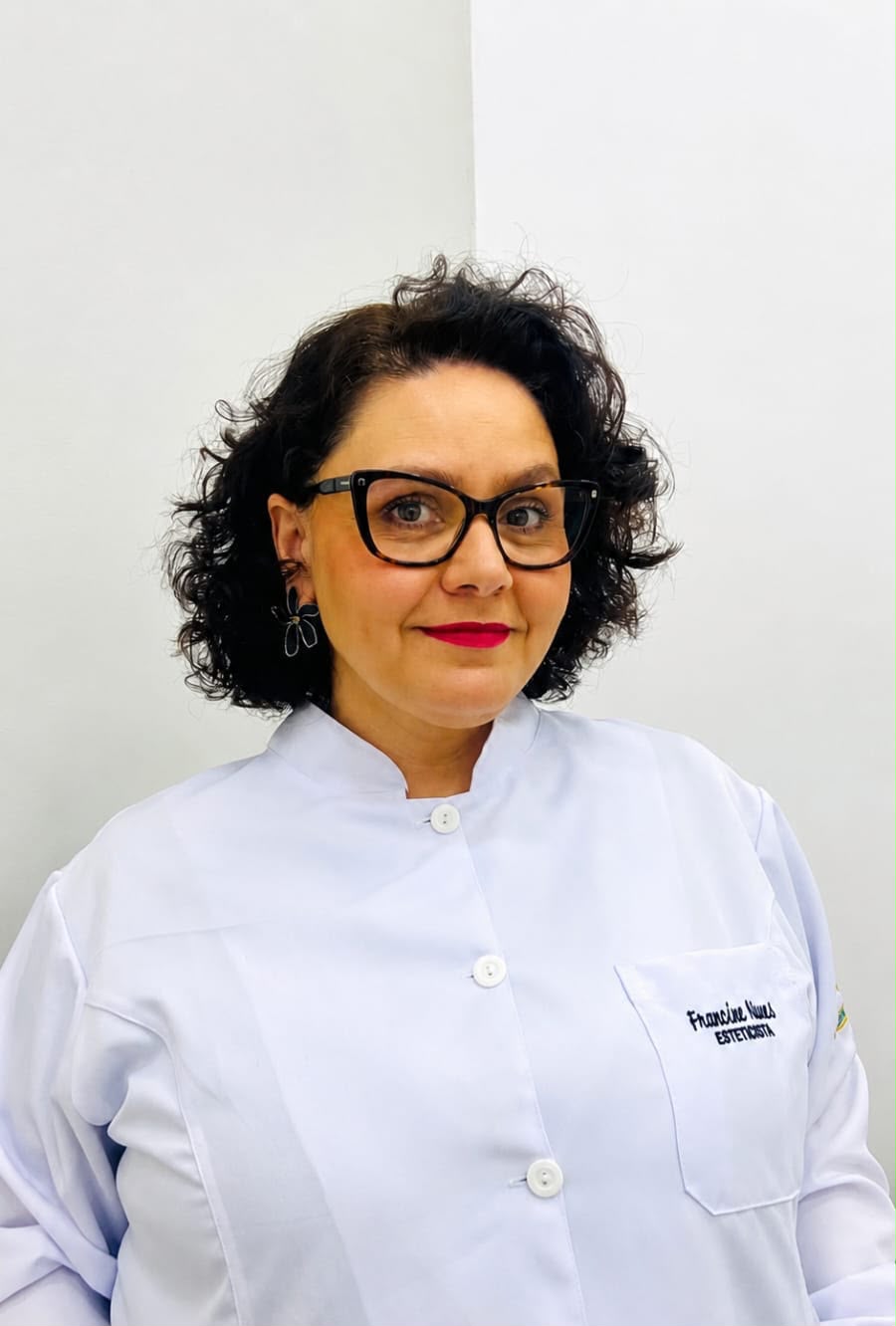 Francine Nunes, esteticista, sorrindo em jaleco branco no consultório